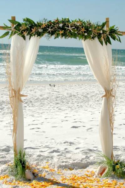 Our two pole bamboo wedding arbors are decorated with tropical flowers and